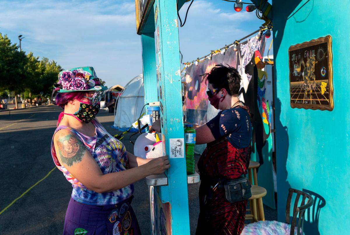 Sachi, left, and Danny set up the Unicorner camp at Summer Spark, a nighttime drive-thru festival inspired by Burning Man, at the Mine Shaft Center in Rancho Cordova on Friday, July 24, 2020.