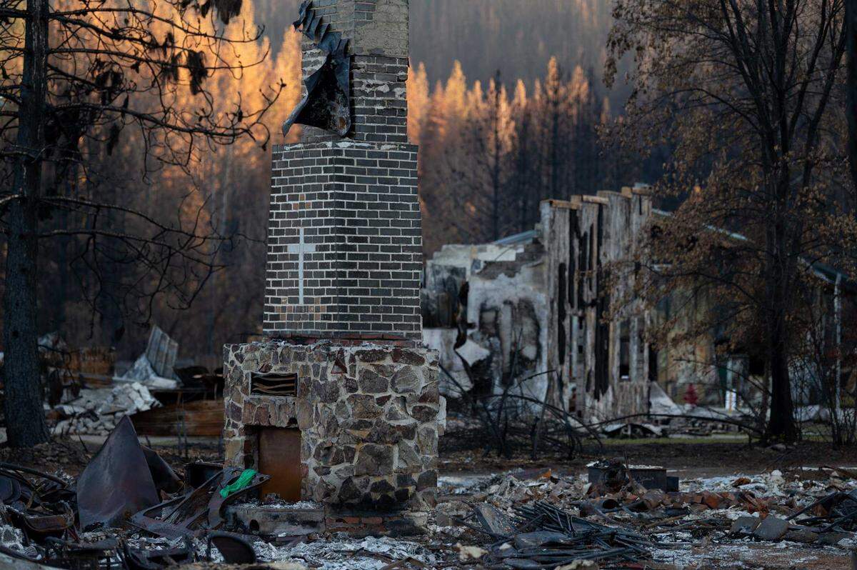A chimney from a home destroyed by the Dixie Fire stands in the town of Greenville in December 2021. Californians have seen the costs of insuring their homes soar and coverage options evaporate.