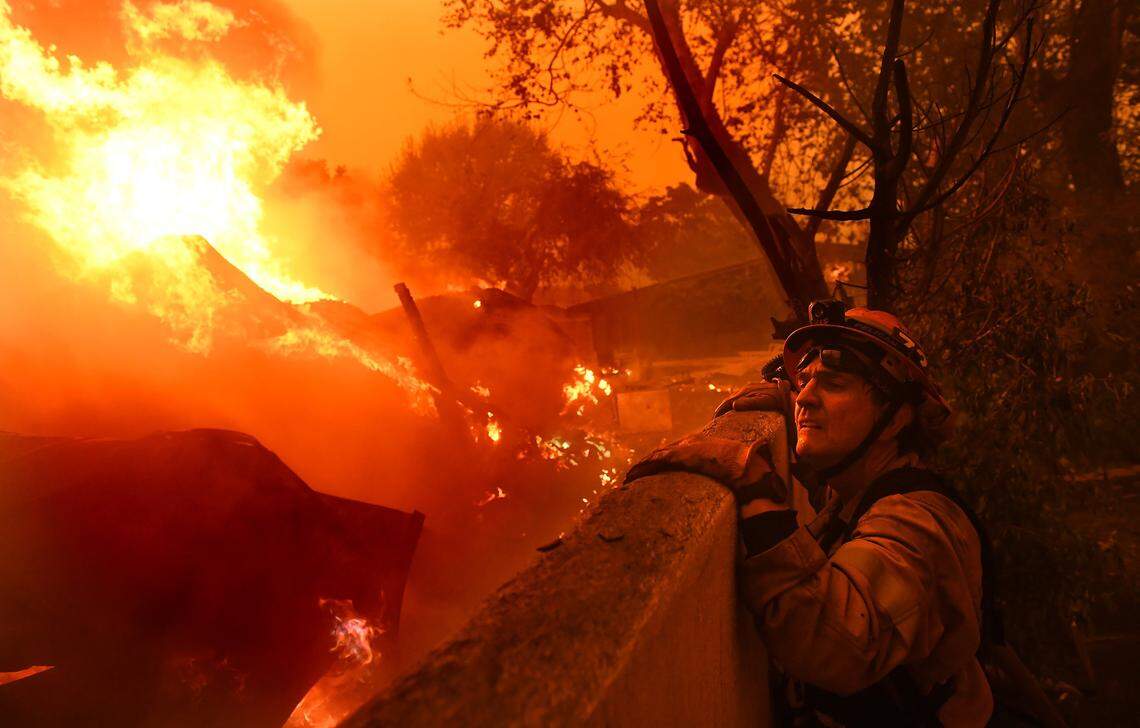 Mayor and firefighter Rick Mullen surveys a house that is on fire in Malibu as the Woolsey fire comes down the hill from Thousand Oaks, Calif., on Friday, Nov. 9, 2018. (Wally Skalij/Los Angeles Times/TNS)