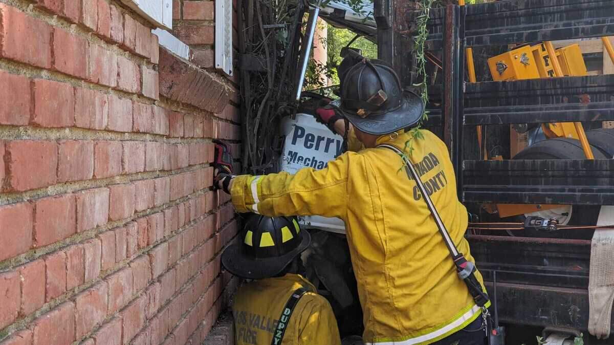 Firefighters on Friday July 17, 2020, work to free a person trapped in a truck that crashed into a school building in the 200 block of South Auburn Street near Highway 49 in Grass Valley, California.