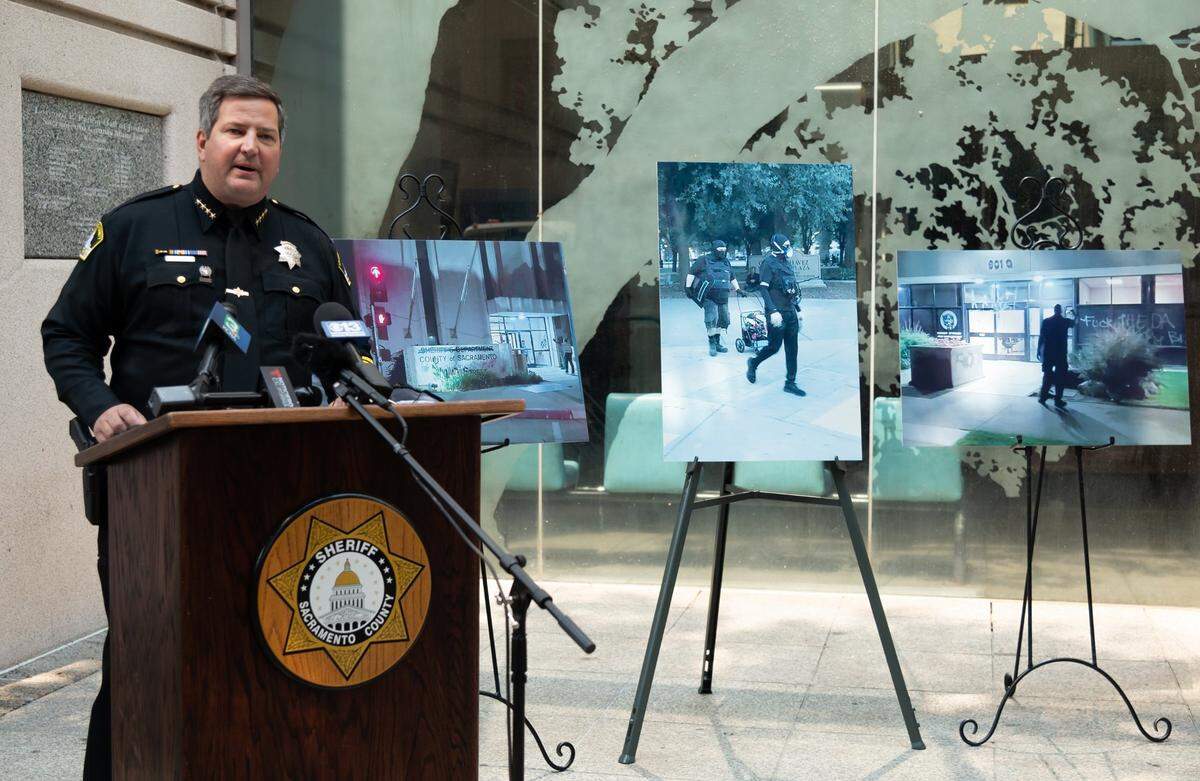 Sheriff Scott Jones discusses a protest in 2020 that resulted in damage to government buildings, and the actions law enforcement would take to protect the buildings in the future, while standing in front of photographs of the protesters and some of the damage.