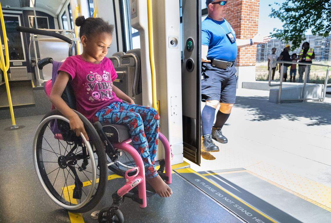 Wheelchair user Desire Holmes, 7, uses a ramp to exit the new S700 low-floor light rail train at the Township 9 station in Sacramento on Wednesday. “When I saw that I said, ‘Perfect,’” said Lisa Silas, a friend of the Holmes family, of the low-floor entry ramp. “They can easily slide right on like the rest of us.”