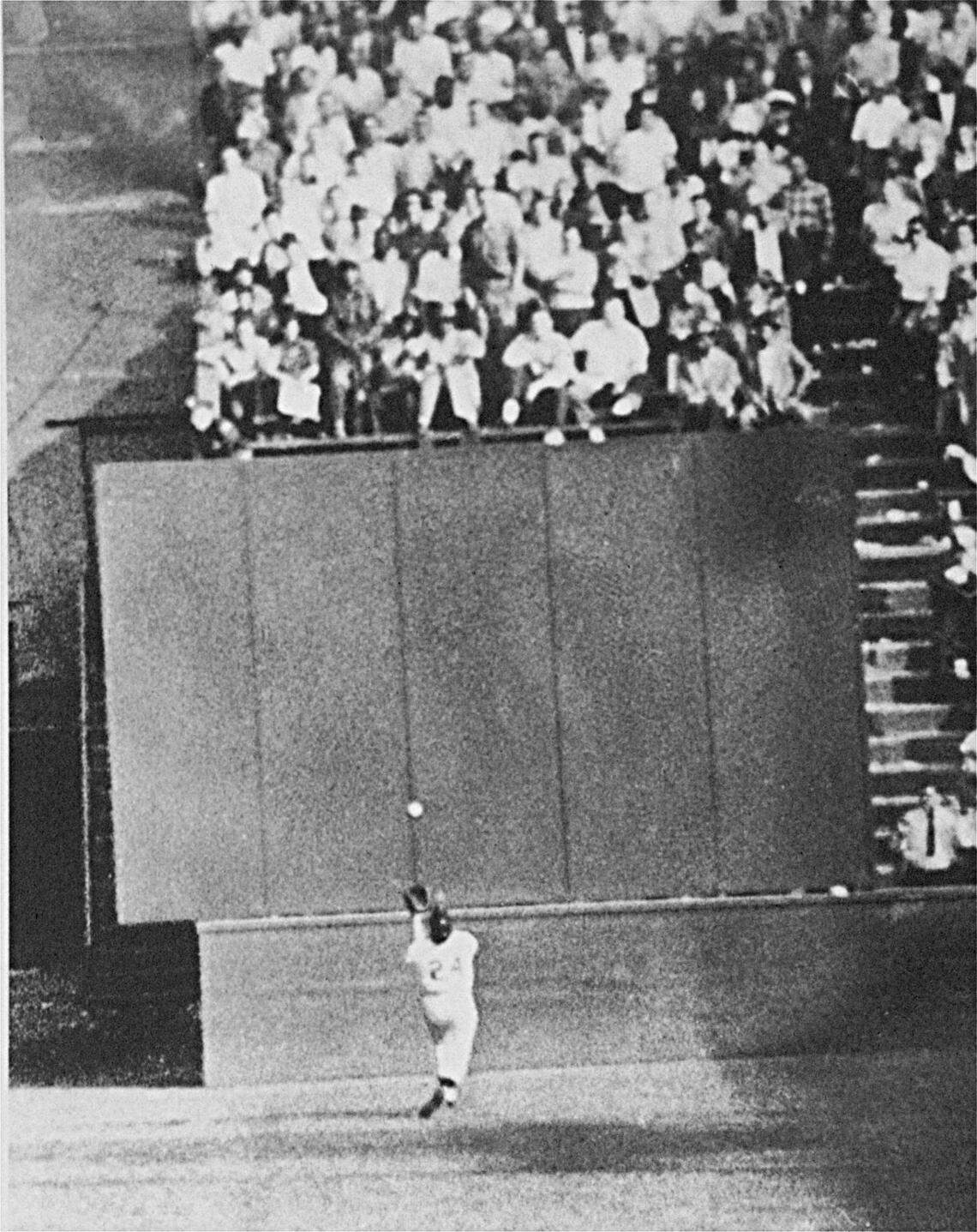 Running at top speed with his back to the plate, New York Giants center fielder Willie Mays gets under a 450-foot blast off the bat of Cleveland first baseman Vic Wertz to pull the ball down in front of the bleachers wall in the eighth inning of the World Series opener at the Polo Grounds in New York on September 29, 1954. In making the miraculous catch with two runners on base, Willie came within a step of crashing into the wall. The Giants won 5-2. (AP Photo)