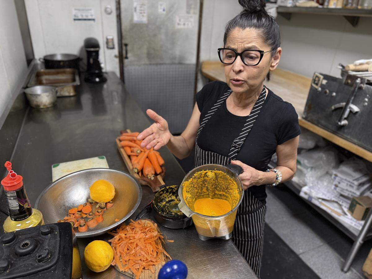 Todo Un Poco’s Marie Mertz blends carrot peels into a sauce to reduce food waste for prepared meals on Saturday, March 21. The meals will be donated to the Rancho Cordova Food Bank three times weekly.