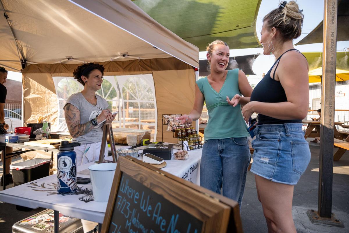 Angelika Feldman, left, who owns Flora & Fauna Provisions with partner Christopher Lee, takes an order from Julia Lund, center, and Carly Goldstein, both of Sacramento, at the pop-up set up for the evening outside Nitty’s Cider in July. The two ended up ordering one of everything for their table of friends. “I would probably bet money that they were locally sourced,” Lund said of the tomatoes in their order. “Essentially all of our produce comes directly from farmers, almost rarely from purveyors,” Feldman said, “we’re always making what’s fresh and seasonal.”