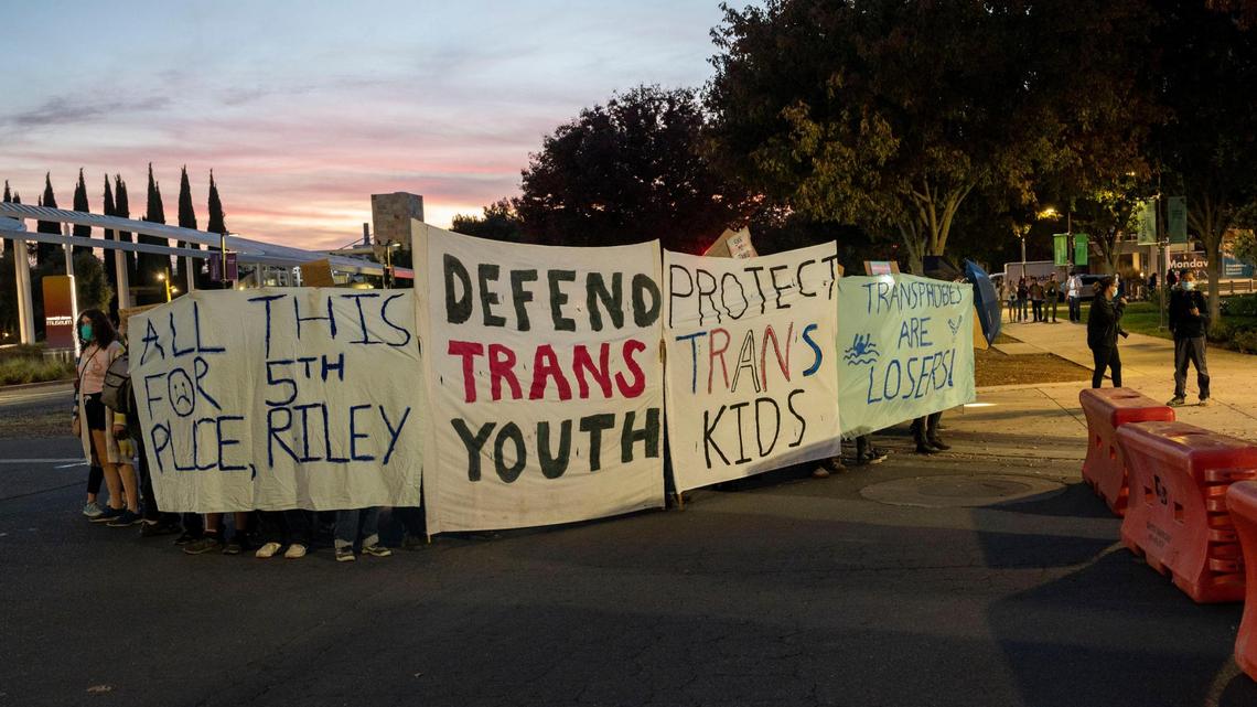 A group of protesters defending trans youth gather outside the conference centers at UC Davis as controversial speaker Riley Gaines, known for her outspoken views against trans-women in sports, prepares to speak in 2023. 