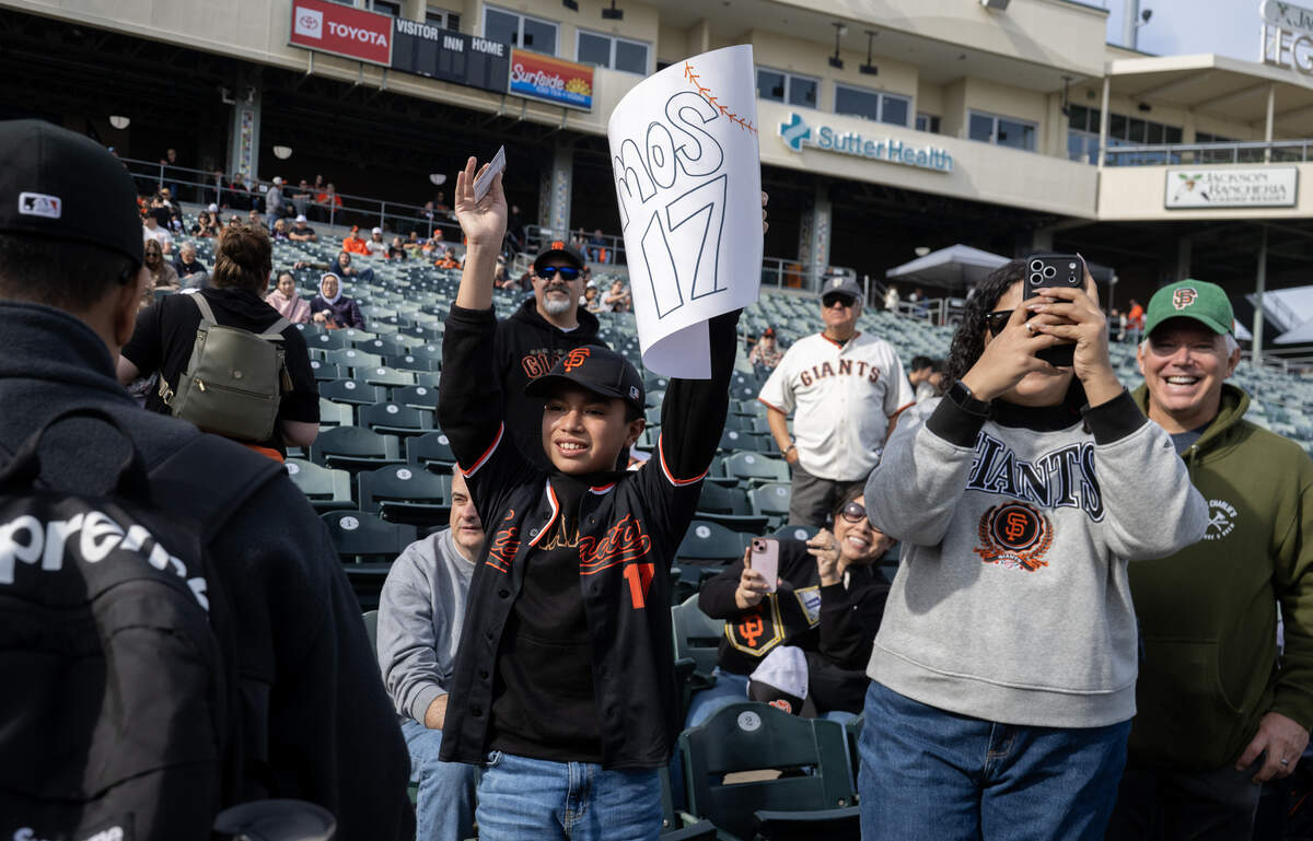 Cesar Aguilar tries to get the attention of his favorite player, Elliot Ramos, at the San Francisco Giants Fanfest at Sutter Health Park on Saturday in West Sacramento. Morning fog prevented Aguilar from arriving in time to get in line for an autograph.