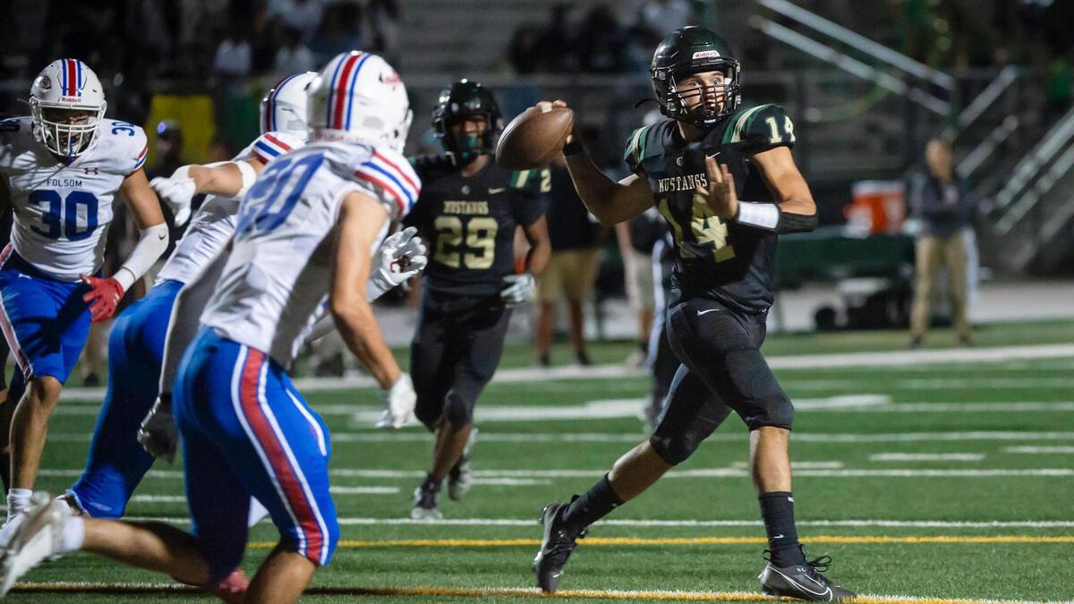 Monterey Trail Mustangs quarterback Joseph Barrientos (14) looks to pass downfield in the second half of the opening night game on Friday, Aug. 18, 2023, at Monterey Trail High School in Elk Grove.
