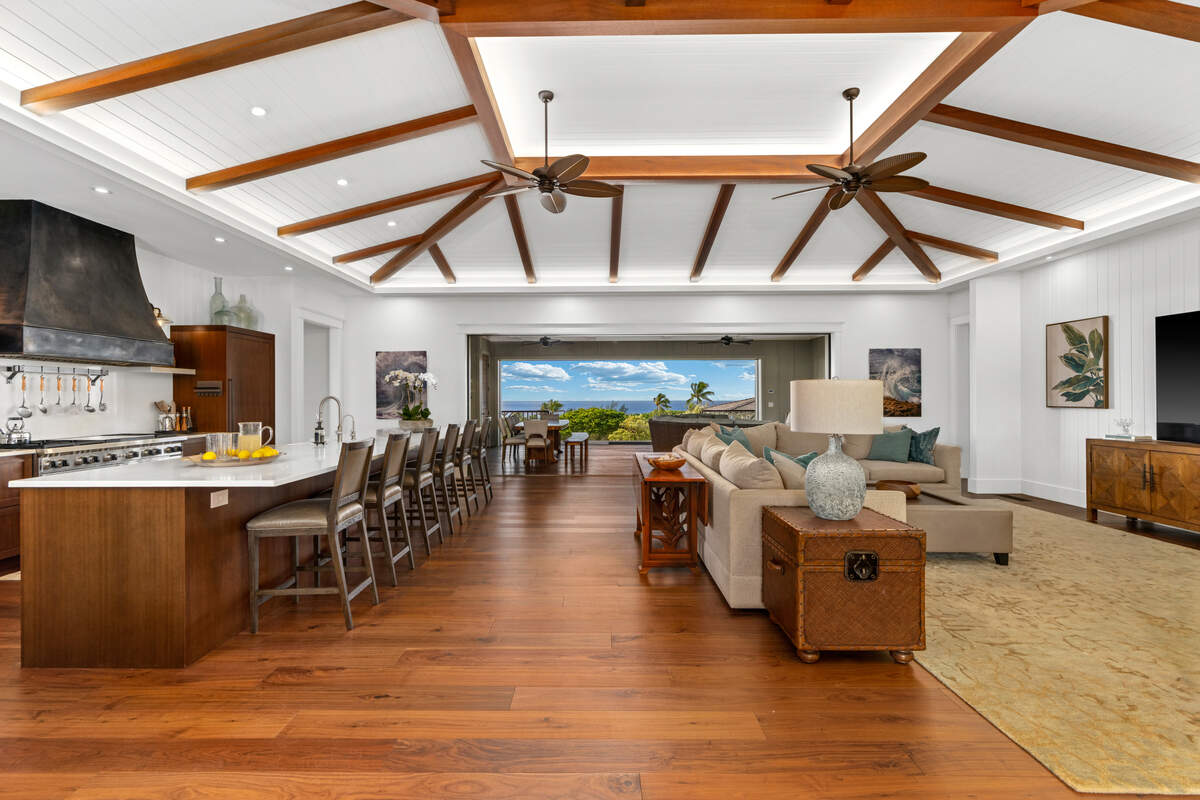 The great room’s vaulted ceilings and museum-grade Koa furnishings draw the eye straight to sweeping Pacific Ocean views and dramatic Spouting Horn eruptions.