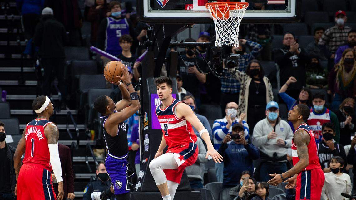 Sacramento Kings guard De’Aaron Fox (5) shoots a basket defended by Washington Wizards forward Deni Avdija (9) in the second half during a game at the Golden 1 Center on Wednesday, Dec 15, 2021, in Sacramento.