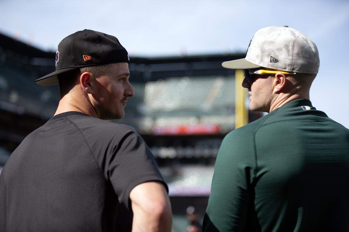 May 16, 2025; San Francisco, California, USA; Former teammates San Francisco Giants third baseman Matt Chapman (left) and Athletics outfielder Seth Brown (15) chat before their game at Oracle Park. Mandatory Credit: D. Ross Cameron-Imagn Images
