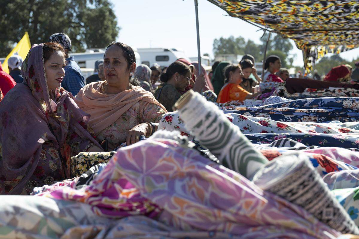 Members of the Sikh purchase fabric and other goods from vendors during Nagar Kirtan, also known as the Sikh Parade, in Sutter County on Sunday, Nov. 2, 2025.