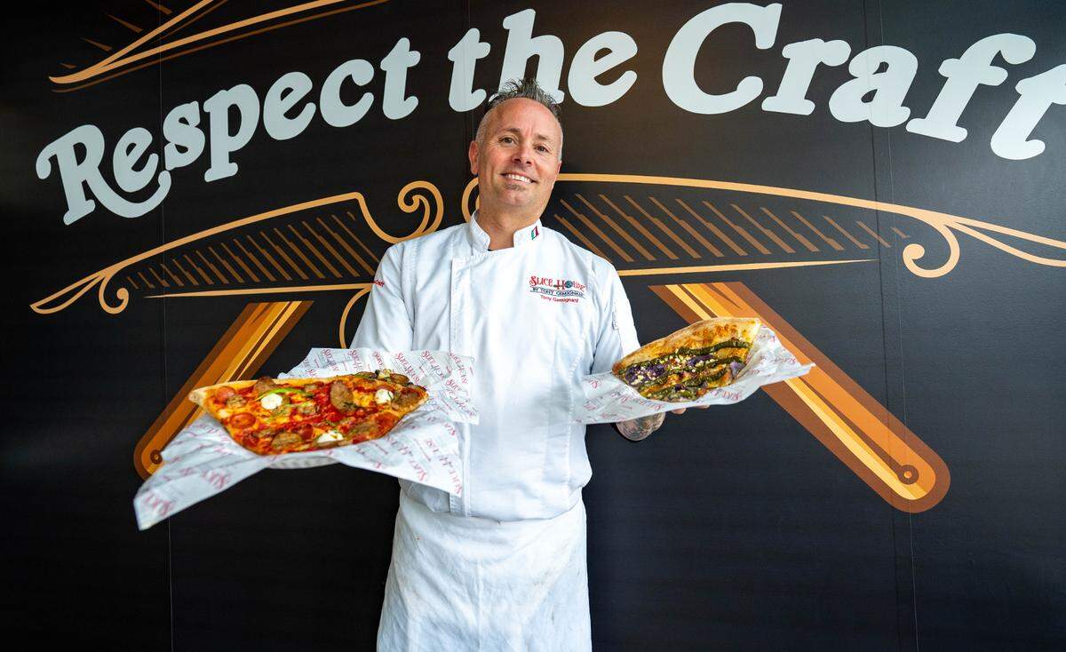 Tony Gemignani, Slice House franchise owner, holds a New York style pizza, left, and a Purple Potato pizza, right, on Thursday, Feb. 1, 2024.