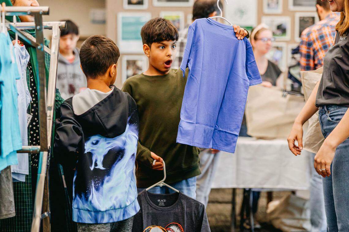 Sayed Jamil Sadat, 10, checks out a shirt’s design at Starting Point’s Hello Summer clothing event in May. Children received tops, toys, hygiene kits and more in preparation for summer.