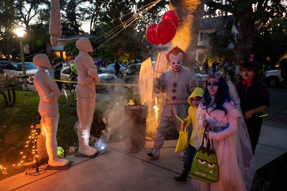 Trick or treaters walk up a driveway to ask for candy in East Sacramento’s Fab 40s in neighborhood on Halloween Tuesday, Oct. 31, 2023.