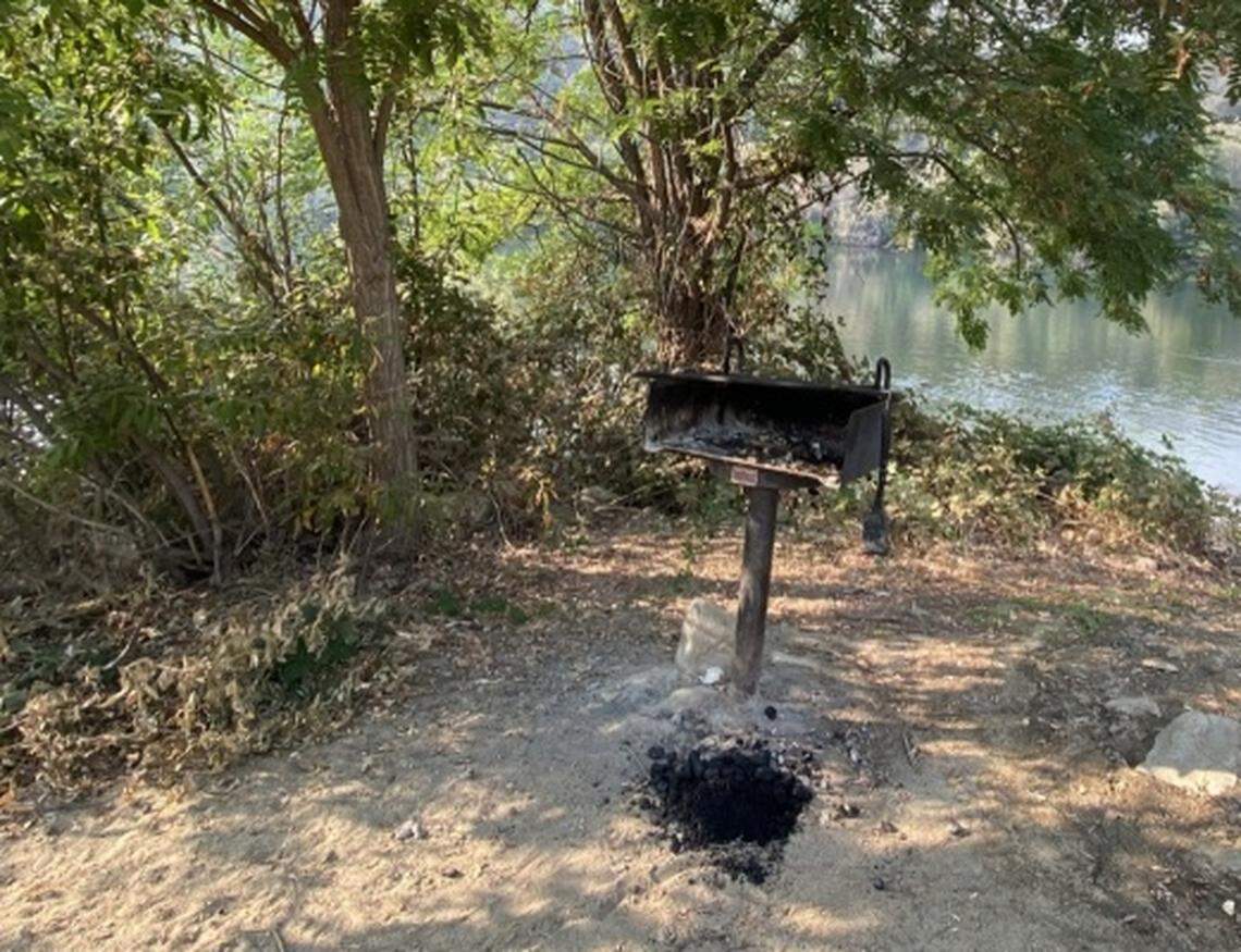 Coals from a barbecue litter the ground at Henningsen Lotus Park in El Dorado County, about 20 miles from where the Caldor Fire started.