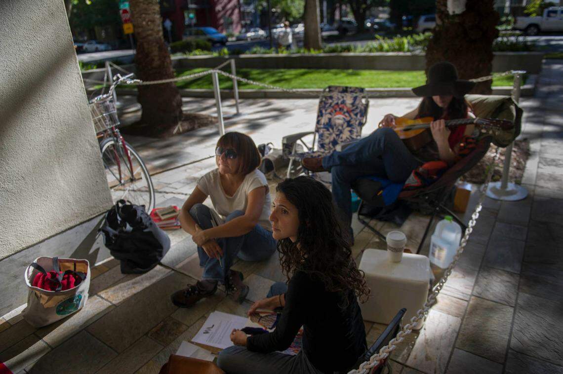 Documentary photographer Janine Mapurunga, foreground, painter Sandy Hernandez, middle, and designer Alison Sharkey are the first three camp on the sidewalk to have first pick of apartments at the Warehouse Artist Lofts on R Street in 2014. The lofts are in a renovated warehouse, and preference was given to literary and creative artists with below median incomes.