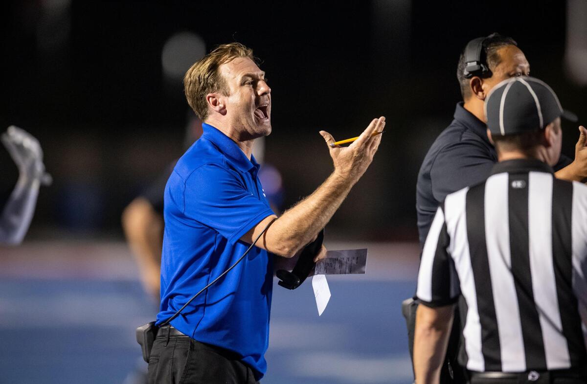Folsom High School Bulldog head coach Paul Doherty communicates with his team as they play against Monterey Trail on their opening night game Aug. 19 at Folsom High School.
