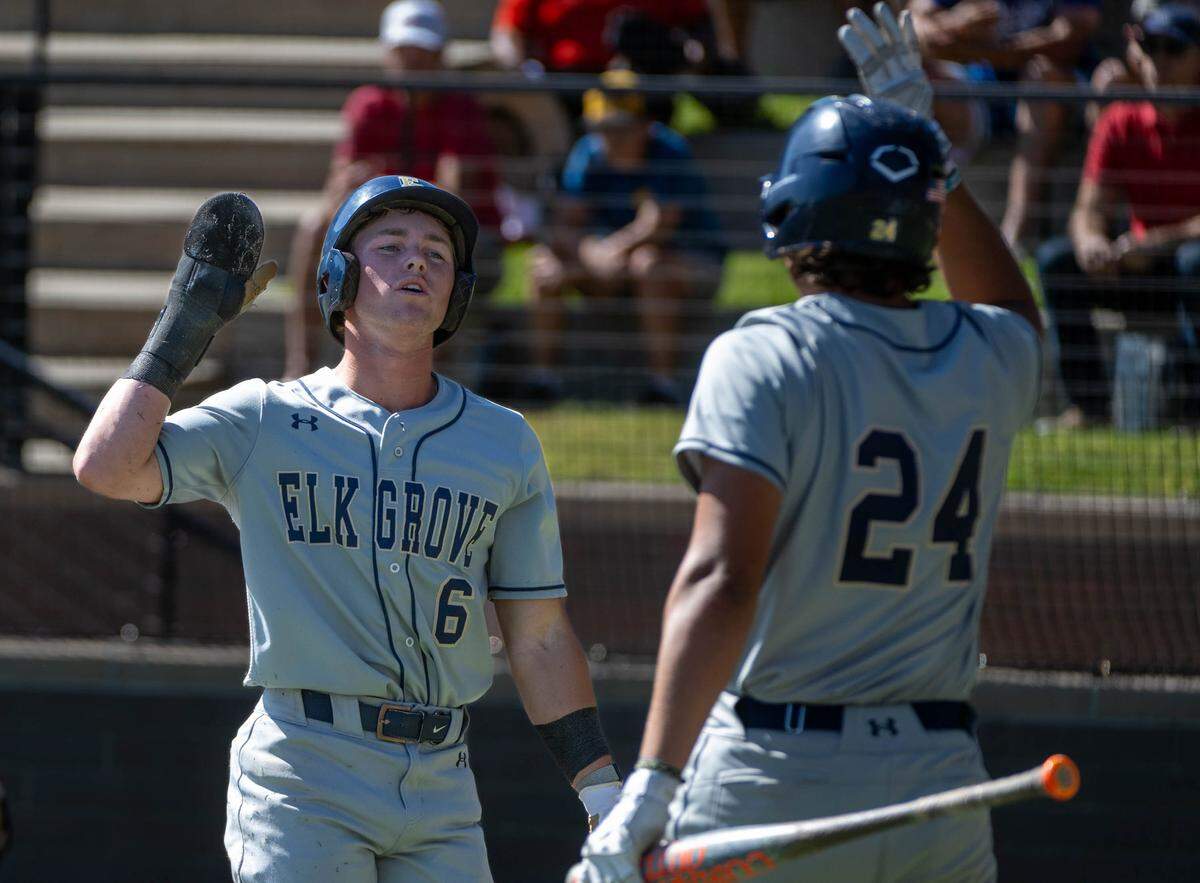 Elk Grove Thundering Herd’s Chase Groves (6) is congratulated by Gavin Martin (24) after scoring a run in the first inning against the Jesuit Marauders during a CIF Sac-Joaquin Section Division II baseball semifinal game at Jesuit High School on Thursday in Carmichael.