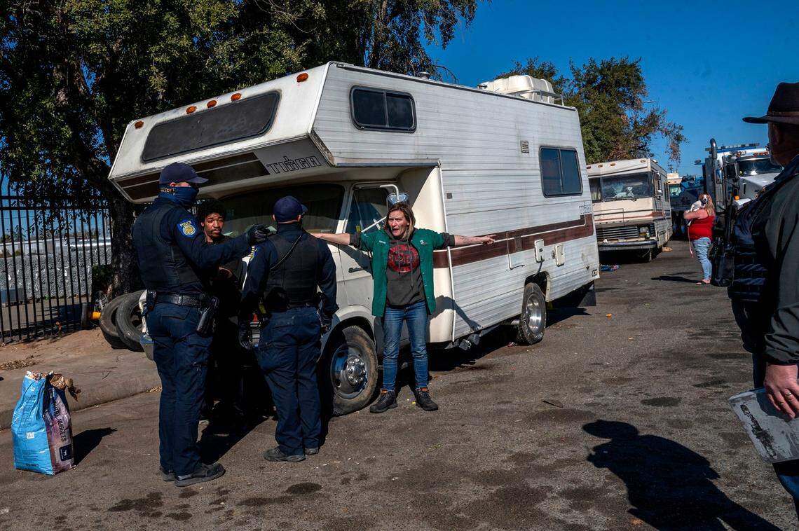 Summer Hamilton, 34, tries to stop Sacramento city crews from towing her fathers RV from a homeless encampment on Evergreen Street on Wednesday. While the RV was towed, Hamilton’s own vehicle was given a three-day extension because she has four children.