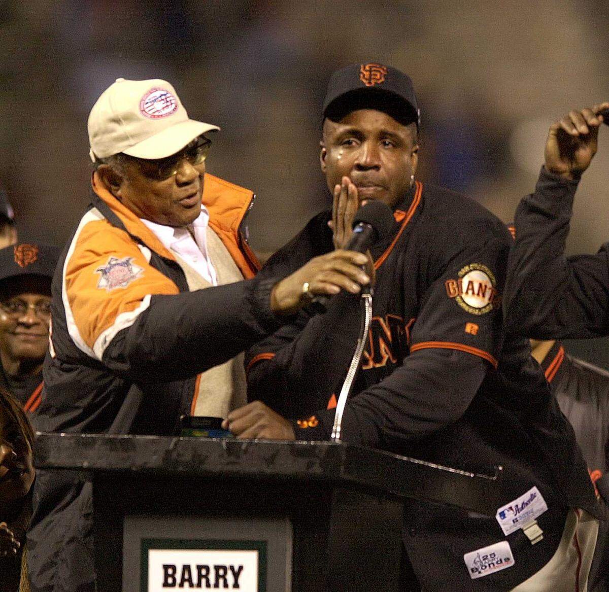 San Francisco Giants slugger Barry Bonds cries at the podium near the pitching mound with his godfather, Willie Mays, during a post-game ceremony after Bonds hit his 71st and 72nd home runs of the season against the Los Angeles Dodgers at then Pacific Bell Park on Oct. 5, 2001. The Hall of Famer center fielder and a slugging icon died Tuesday, June 18, 2024, at the age of 93, the Giants organization announced.