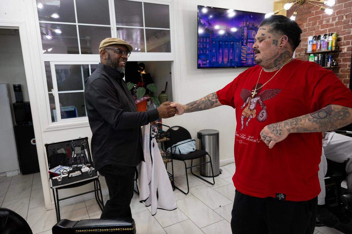 Marichal Brown finishes fist bumps customer Joe Chavarria after his haircut at HAIRitage Salon on Thursday, Feb. 29, 2024, in Sacramento. Brothers Marichal and Rodney Brown are owners of HAIRitage Salon and their shop are also part of a growing national network of Black barbers and stylists who have become frontline mental health advocates in their communities as part of the Confess Project. The project trains and helps Black haircare and other workers to help be mental health advocates for Black men, boys and their families.