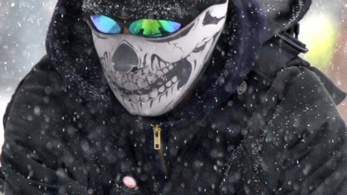 Snow flies around a bicycle messenger wearing a ski mask and glasses in 2011. How can you stop glasses from fogging up while wearing a mask? There are some fixes you can try. (AP Photo/Keith Srakocic)