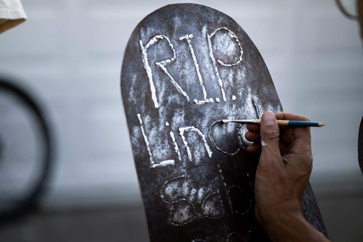 Aaron Shaw highlights letters on the sign to remember Lincoln Sabini, a UC Davis student who was killed in a cycling crash, before a memorial ride in Davis on Wednesday.