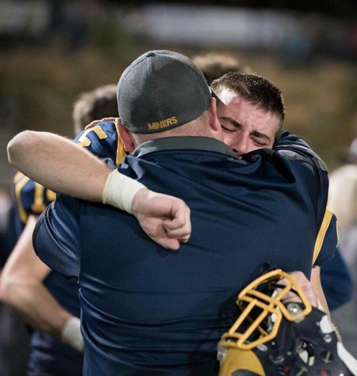 Nevada Union High School football coach Dennis Houlihan and Tyler Nielson share an embrace during the 2017 season.