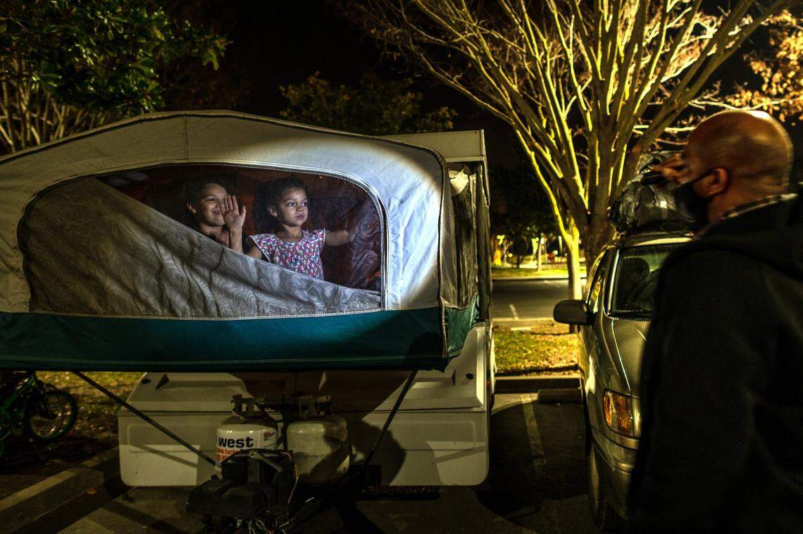 Aryanna and Shyann Slain wave good night to their father before going to sleep in a camper in a Natomas park, after their parents couldn’t afford a motel in January. “As long as my kids are smiling I don’t feel too bad,” said Slain.