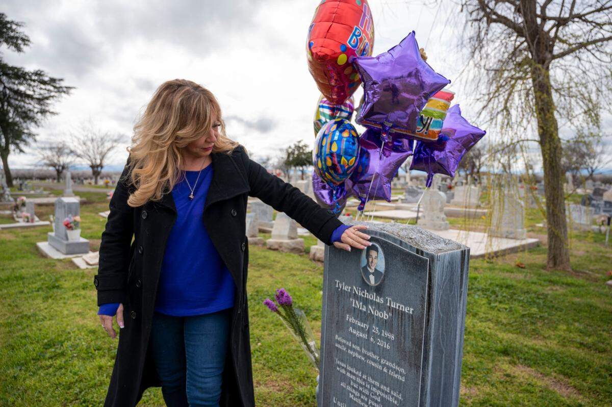 Francine Turner touches the image of her son Tyler on his gravestone in Los Banos after kissing her fingers on his birthday, Feb. 25.