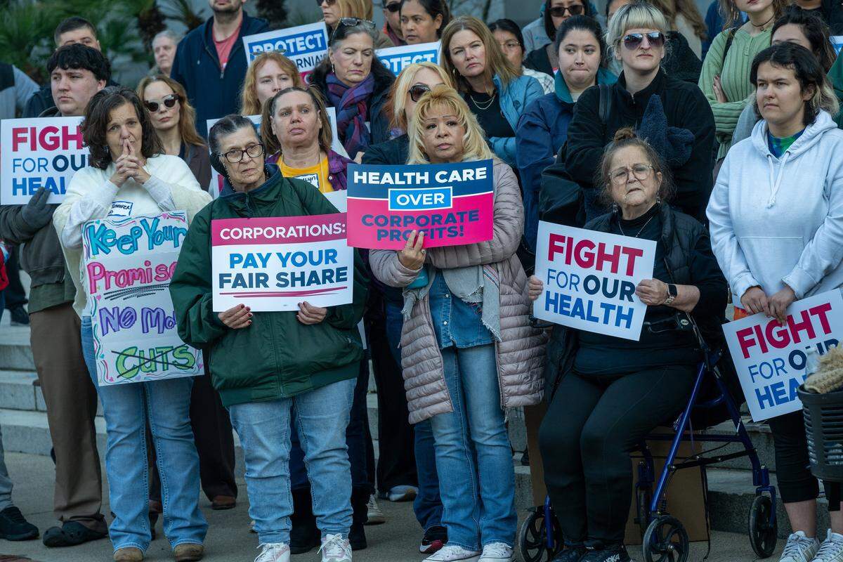 Health care workers hold signs at a health care rally at the state Capitol on Jan. 14 in Sacramento. They were listening to Assemblymember Mia Bonta, chair of the Assembly Health Committee, speak.