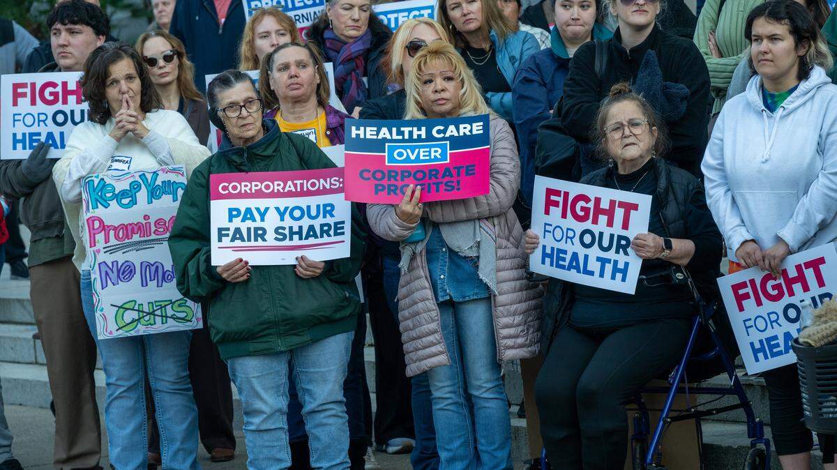 Health care workers hold signs at a “Fight for Our Health” rally at the state Capitol on Wednesday, Jan. 14, 2026, in Sacramento. They were listening to Assemblymember Mia Bonta, chair of the Assembly Health Committee, speak.