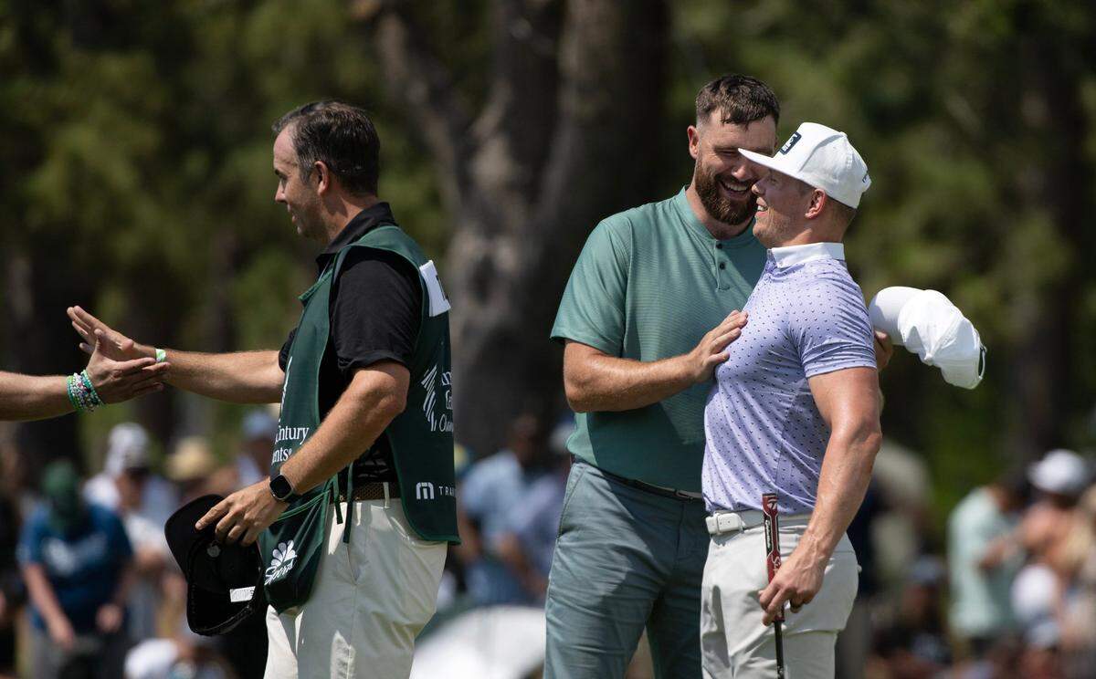 Travis Kelce embraces wrestling star Mike “The Miz” Mizanin, his playing partner, following the first round of the American Century celebrity golf championship on Friday, July 12, 2024, in Stateline, Nev.