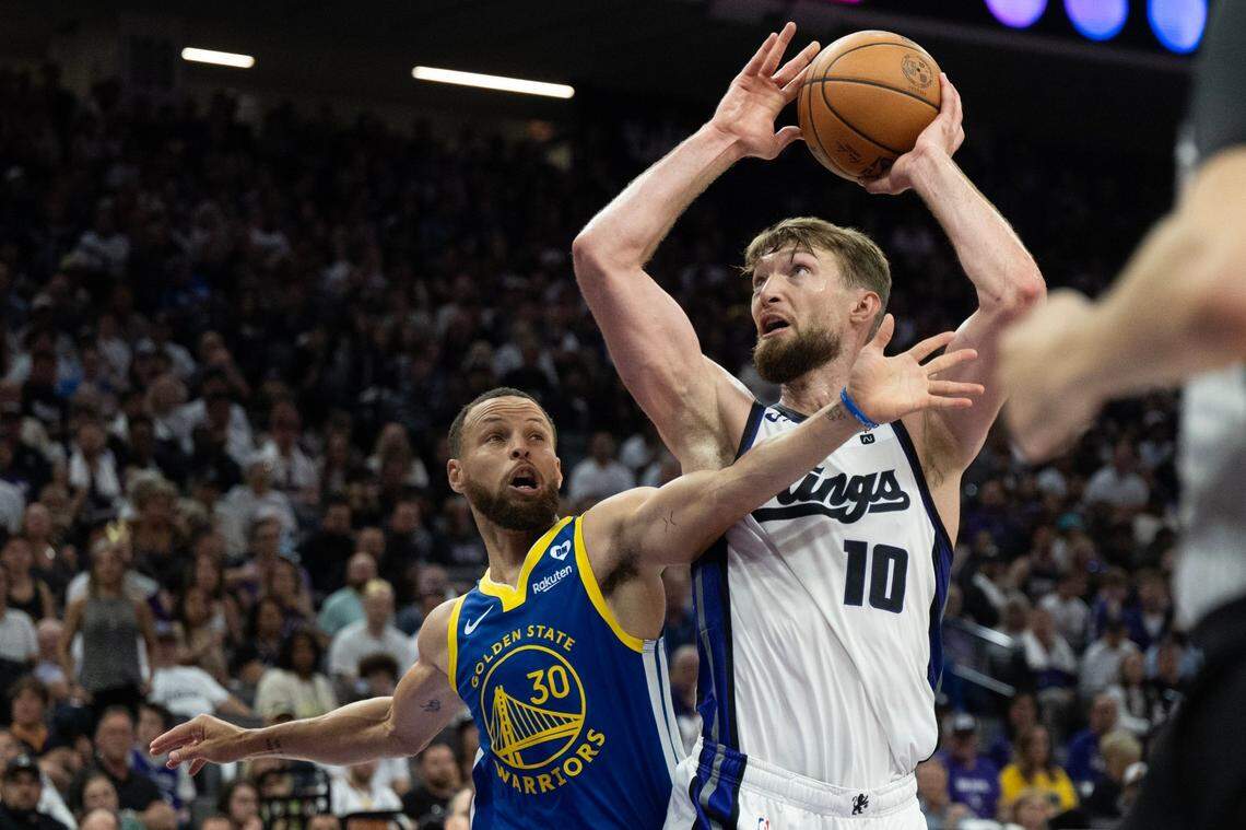 Sacramento Kings forward Domantas Sabonis (10) shoots a basket defended by Golden State Warriors guard Stephen Curry (30) during a play-in game at Golden 1 Center in 2024. 