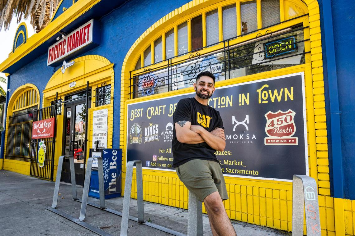Preet Singh, 33, owner of Pacific Market on P Street in midtown Sacramento works at his store on Wednesday, Oct. 12, 2022. The store has been around since the 1930s, Singh said. His family took over the store the last 17 years. “Anything you need, we basically will go out of our way and make it happen for our customers,” he said. At the front of the cash register is a yellow notepad, tucked between packages of dried mango slices and a credit card reader. Labeled, “What Can Pacific Market Get For You?” where customers can scribble down items they want to see stocked on the shelves. Singh a self proclaimed beer connoisseur said he a large selection of local beer on his shelves.
