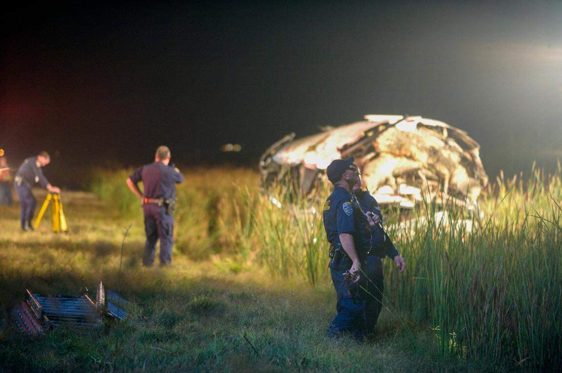 Aided by search lights and a helicopter, emergency crews search for survivors near the wreckage of the bus on Oct. 5, 2008.