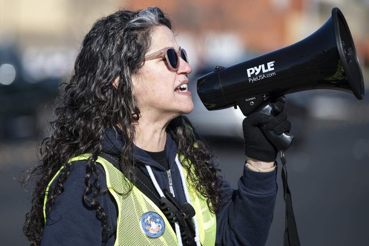 Gina Yarbrough, a physical therapist and UNAC/UHCP representative, yells into a megaphone during a strike outside Kaiser Permanente’s Roseville Medical Center in Roseville on Monday.