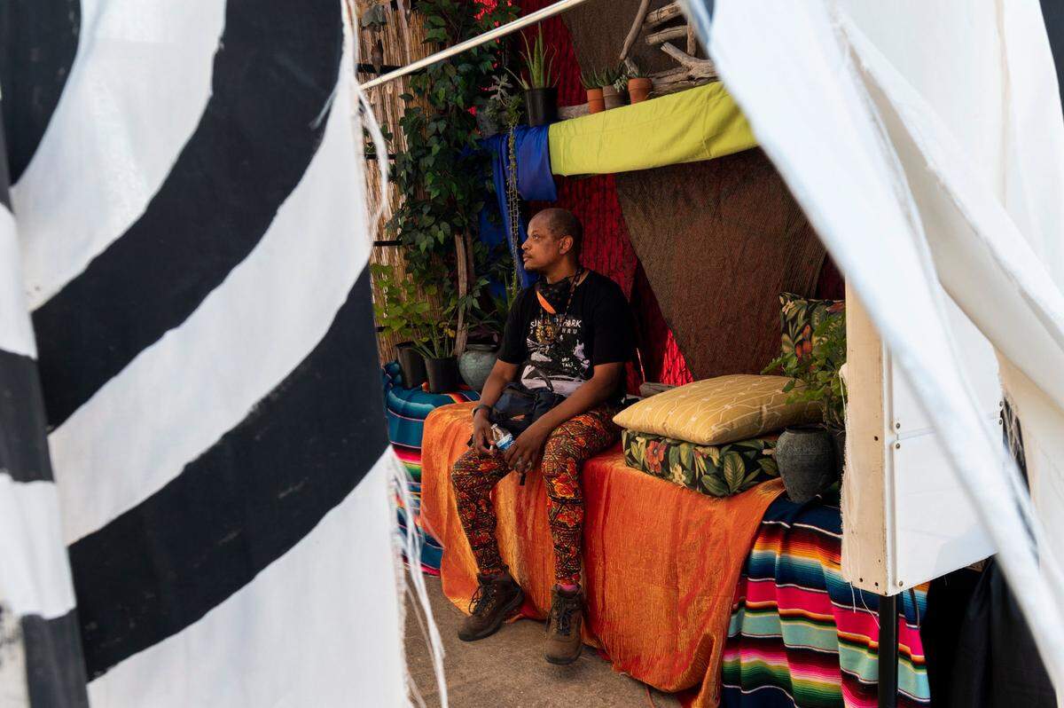 Summer Spark organizer Ed Fletcher rests inside the Sonic tent at the nighttime drive-thru festival inspired by Burning Man at the Mine Shaft Center in Rancho Cordova on Friday, July 24, 2020.