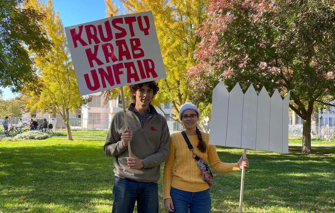 Dan Polin, left, and Morgan Walker, right, pose with their handmade picket signs at the UC Davis academic workers’ strike on Nov. 14, 2022. Polin and Walker are both doctoral candidates in the physics department, and Walker works as a teaching assistant this quarter.