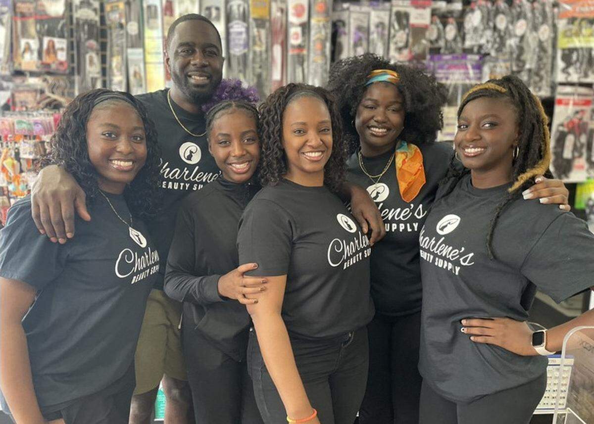 Charlotte Haynes, center, stands in her Elk Grove beauty store with her family.