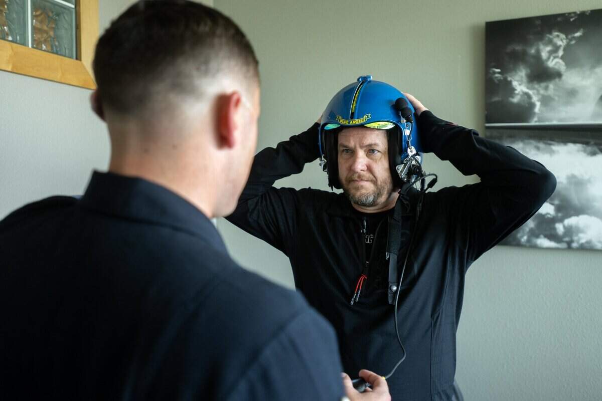 Mills Middle School teacher Jason McKnight adjusts his helmet with the help of Cody Farrell, the Blue Angels Seven crew chief, during a preflight orientation for his 45-minute flight at Mather Airport on Tuesday, March 18, 2025, in Rancho Cordova. The Blue Angels returns to the California Capital Airshow at Mather Airport on March 22 and 23.