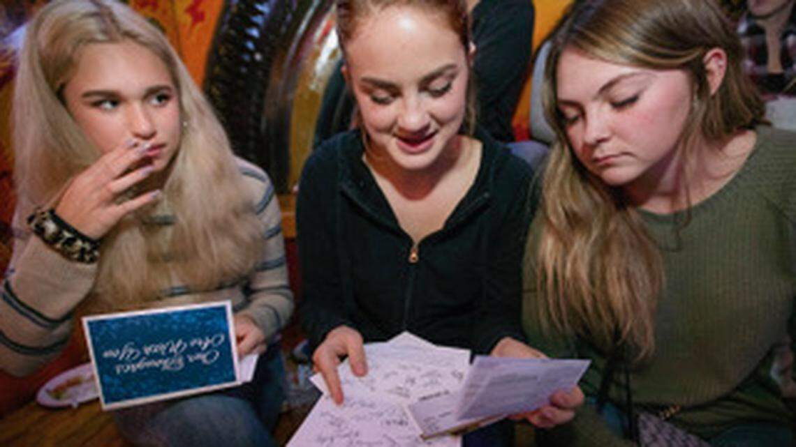 Classmates Tiril Mong 17, left, Gretchen Cassing 18, and Kelsi Rice 17 open cards from well-wishers in Lubbock, Texas during a senior class event at Madison Bear Garden in Chico, CA on Monday, December 10, 2018. Many of the students have lost their homes, and their school to the Camp Fire which destroyed most of Paradise, CA last month. The cards which were signed by dozens of members of a group in Texas contained messages of support, and gift cards. Every student received a card.