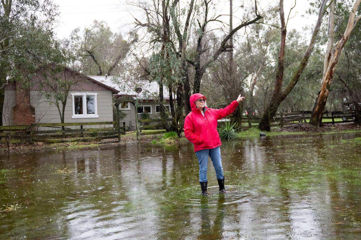 Kristi Rauser of Wilton walks in her flooded yard on Thursday, five days after the Cosumnes River flooded many homes and roads in the area.