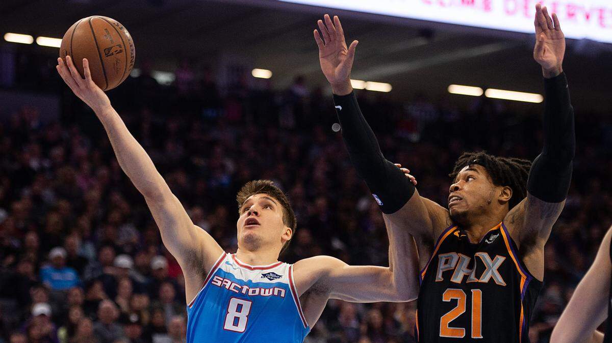 Sacramento Kings guard Bogdan Bogdanovic (8) battles Phoenix Suns forward Richaun Holmes (21) as he drives to the basket Feb. 10 at Golden 1 Center in Sacramento. The Kings and Holmes have agreed to terms on a two-year contract.