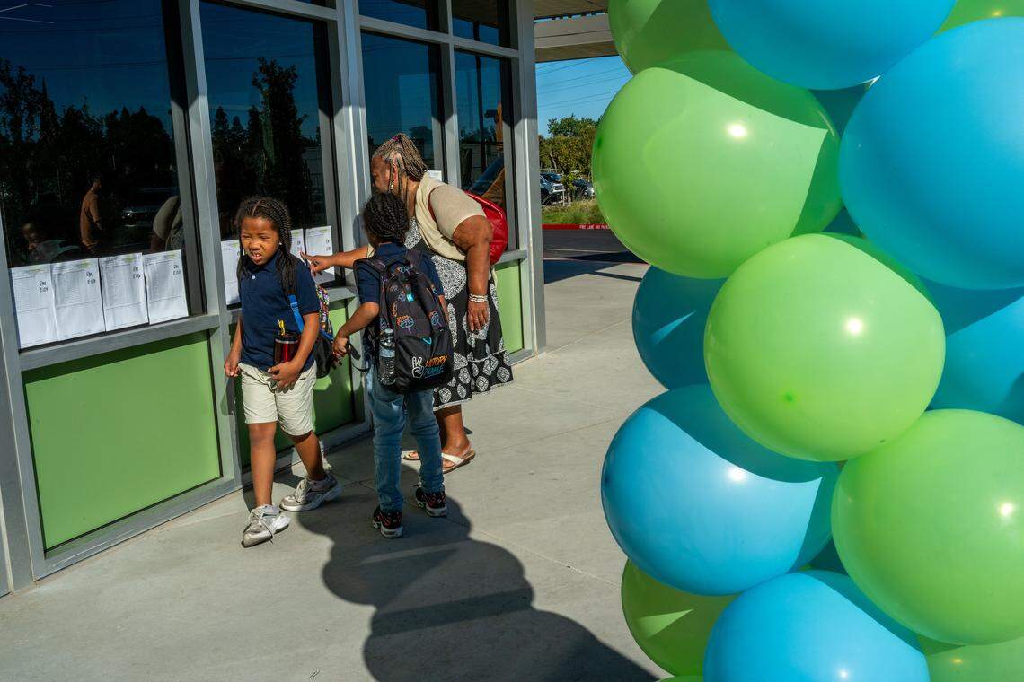Crescendo Manning helps her nephews – second-grader Trelani Manning and third-grader Jelani Manning – locate their classrooms on a chart outside Nicholas Elementary School on Aug. 18, 2025, the first day of school for the Sacramento City Unified School District. The school is one of three in the district recently rebuilt with bond funding.
