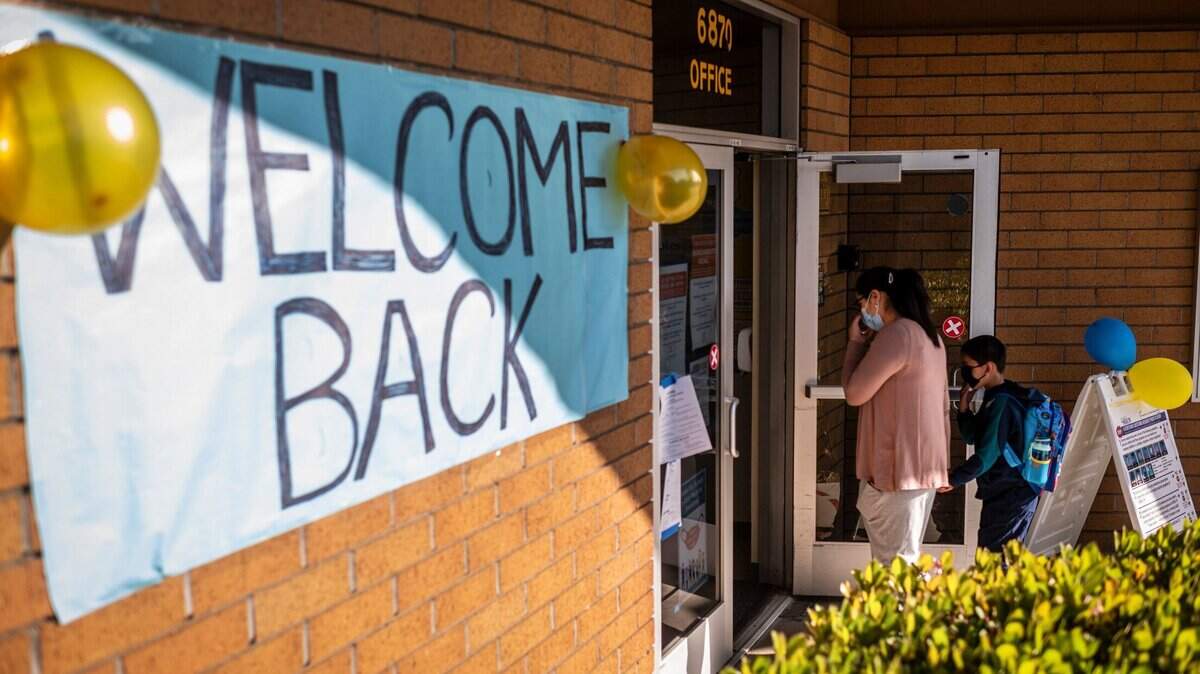 Los estudiantes entran en la escuela antes de la primera campanada en la Caroline Wenzel Elementary, en Sacramento, en 2021.
