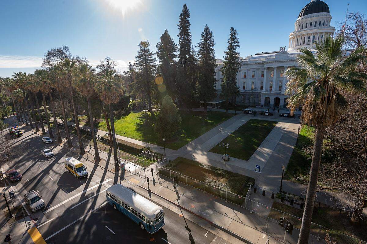 Hundreds of vehicles, including Sacramento Regional Transit’s vintage “Old Blue” bus, join the #ReclaimMLK Day car caravan as it drives past the state Capitol – fenced off because of concerns about Inauguration Day violence – in celebration of Martin Luther King Jr. Day on Monday.