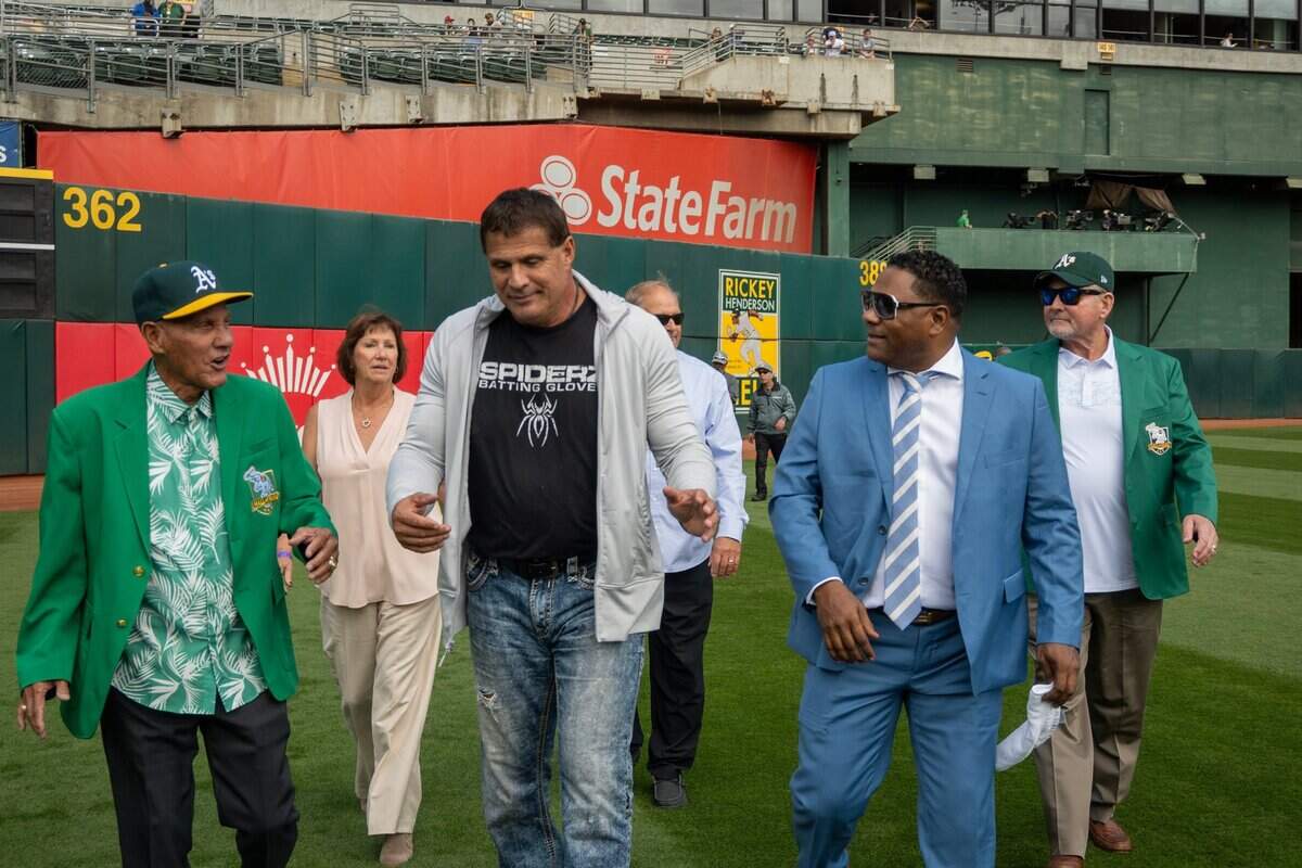 Miguel Tejada, right, walks with José Canseco and Campy Campaneras, left, before induction into the Oakland Athletics Hall of Fame last month.