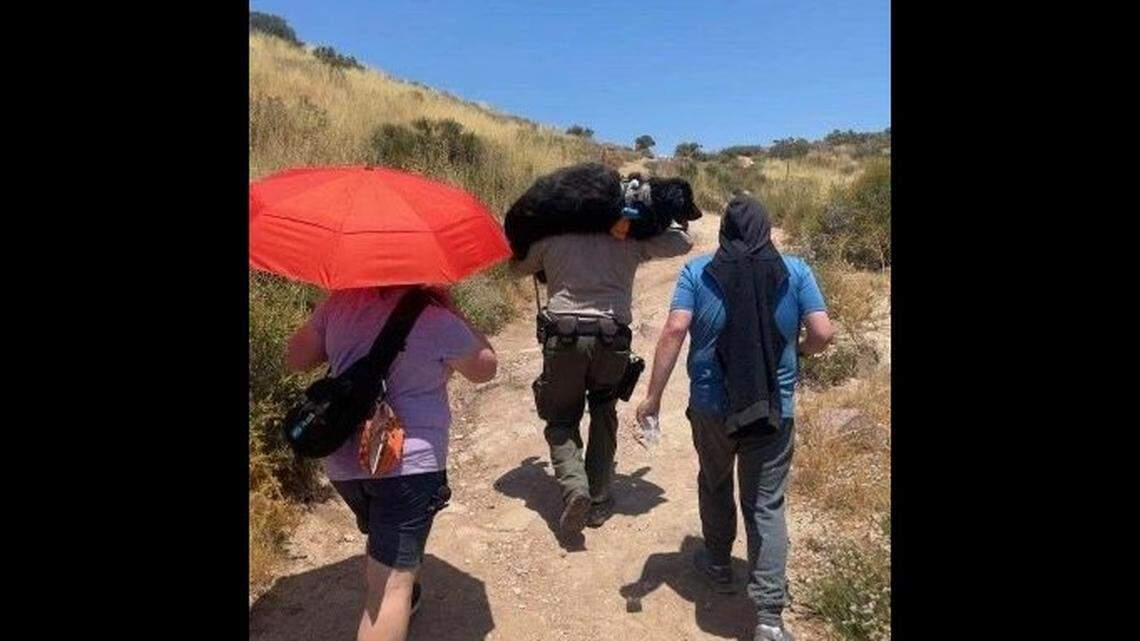 A Los Angeles sheriff’s deputy rescuing lost hikers carried their dog, who was too dehydrated to walk, to safety, California officials say.